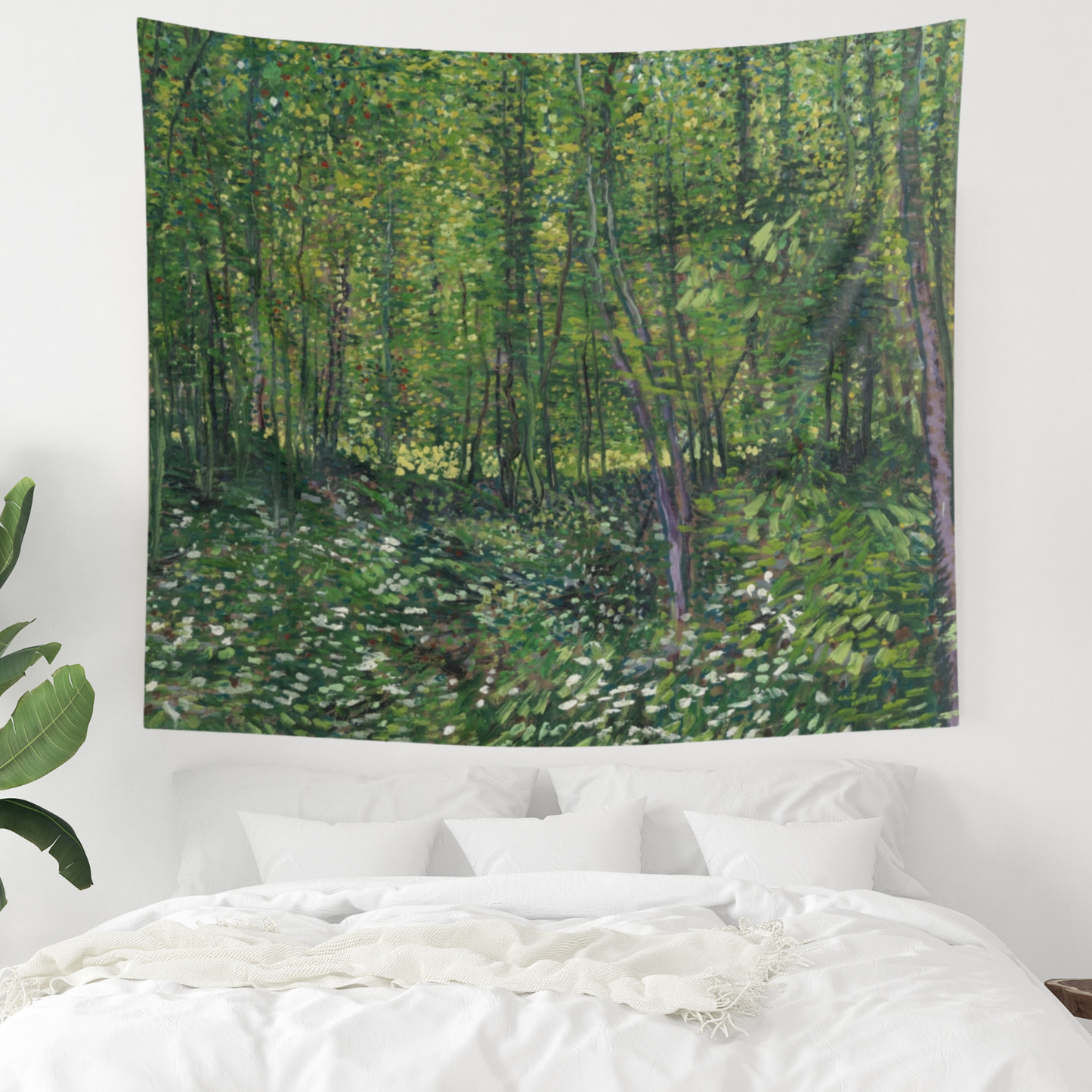 a painting of a lush green forest in a white bedroom
